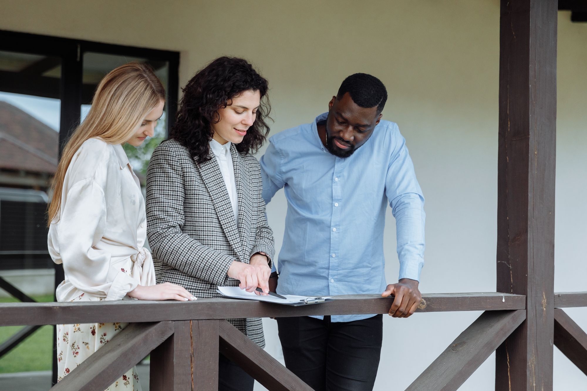 Advisor going over paperwork with a couple on a porch