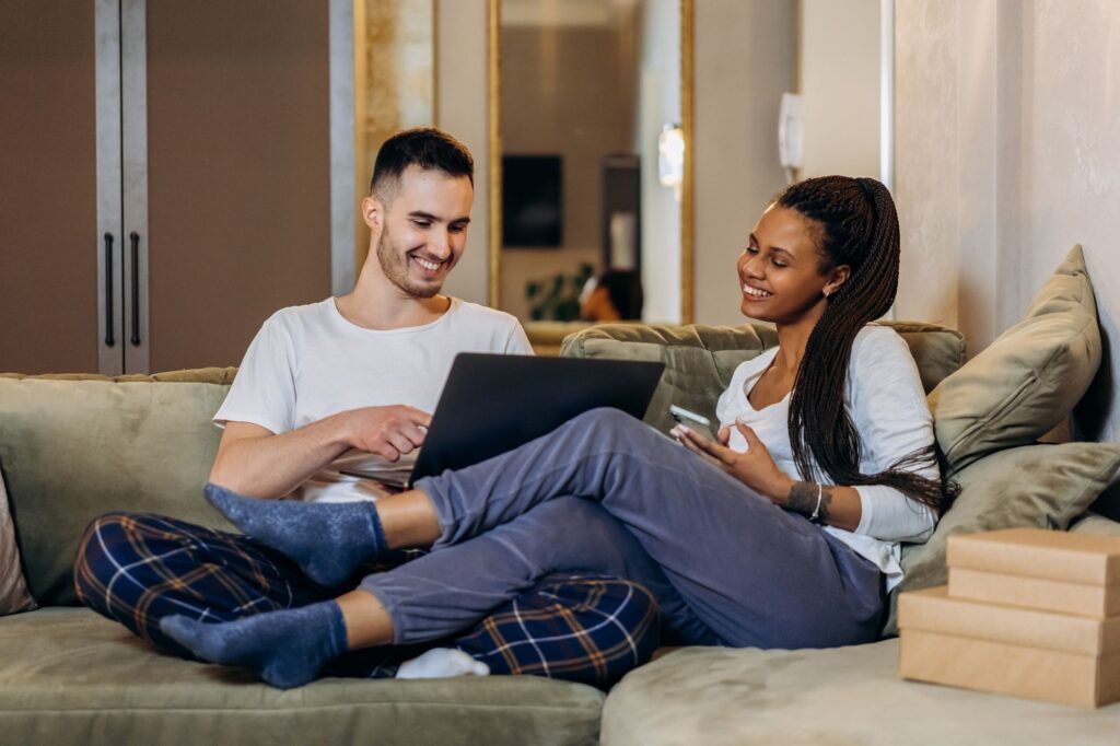 Couple on the sofa looking at a laptop