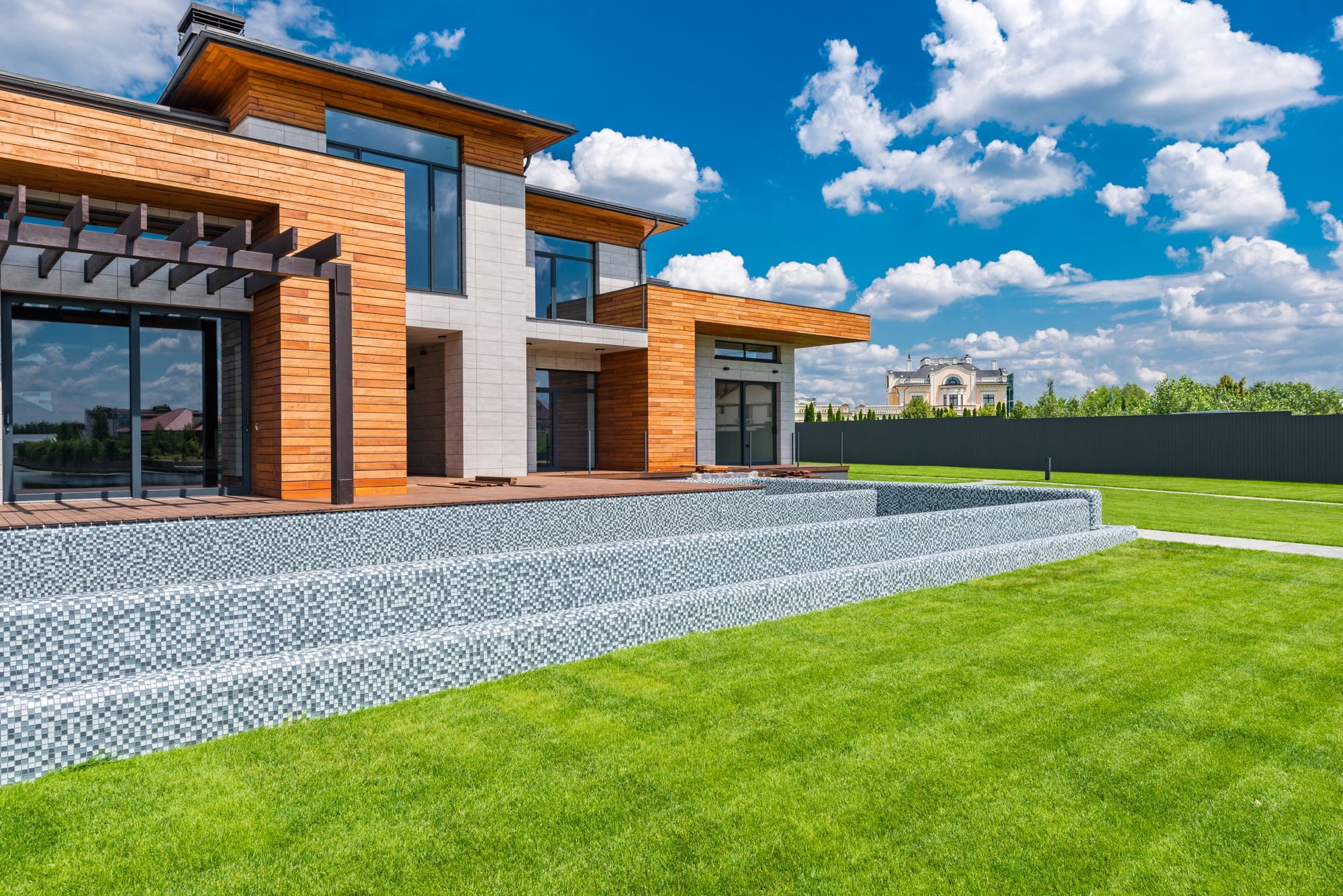 Modern luxury home with a large lawn under a blue sky