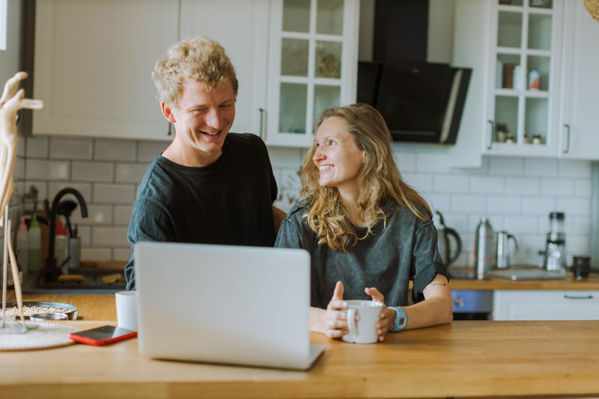 Couple reviewing their finances on a laptop at the kitchen table
