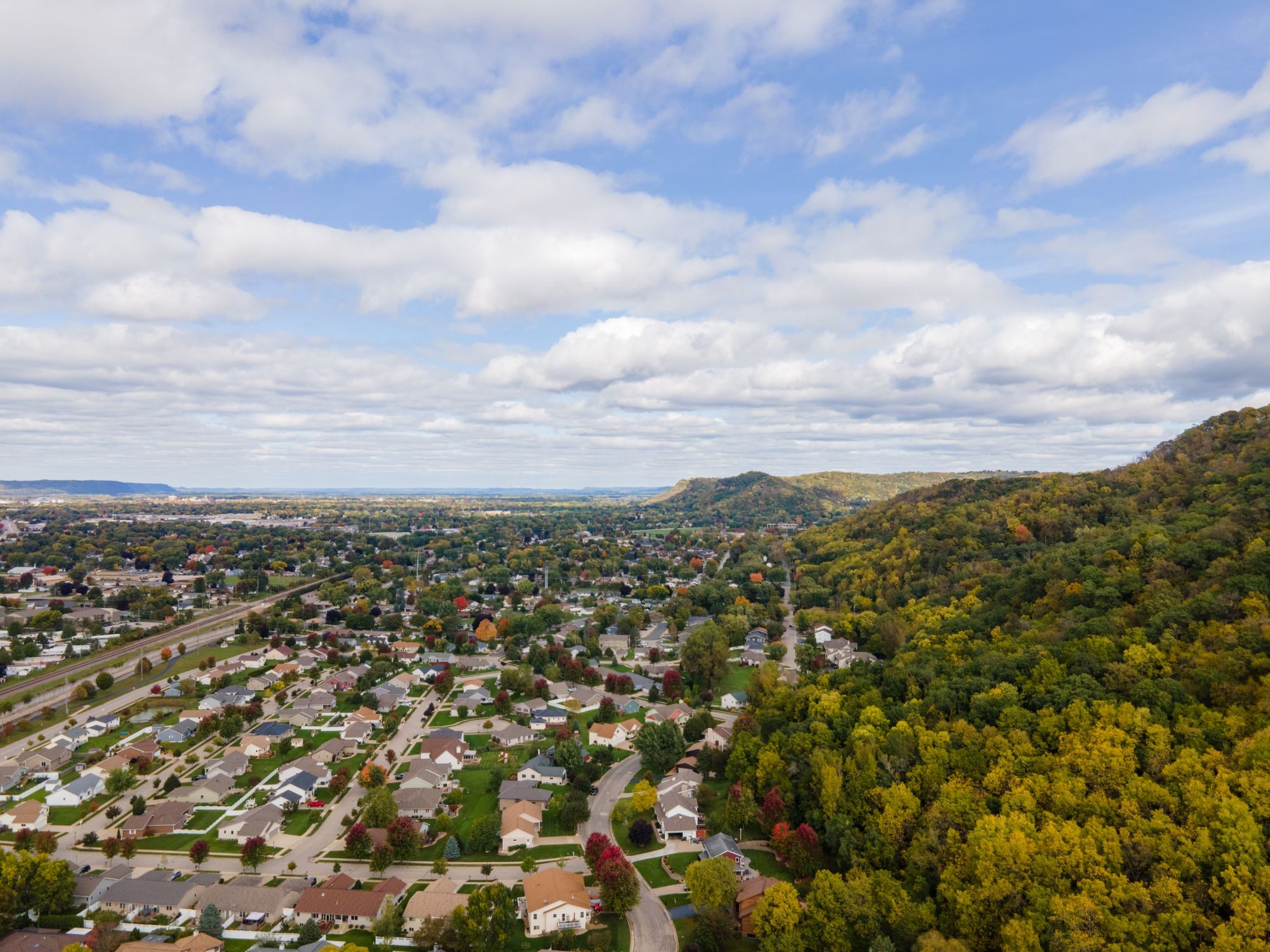 Aerial view of a suburban neighborhood beside a forest