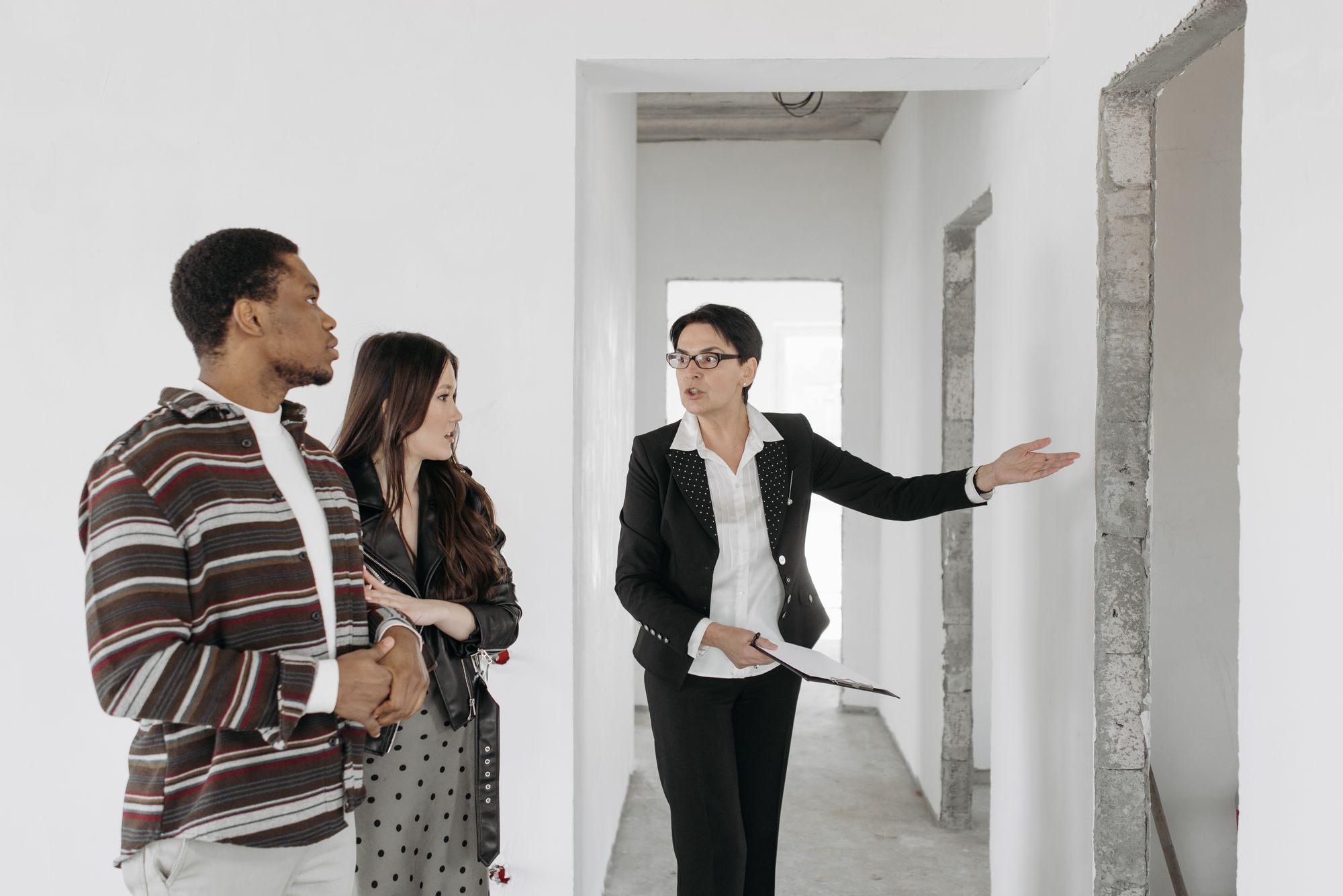 Agent showing a couple through an unfinished house