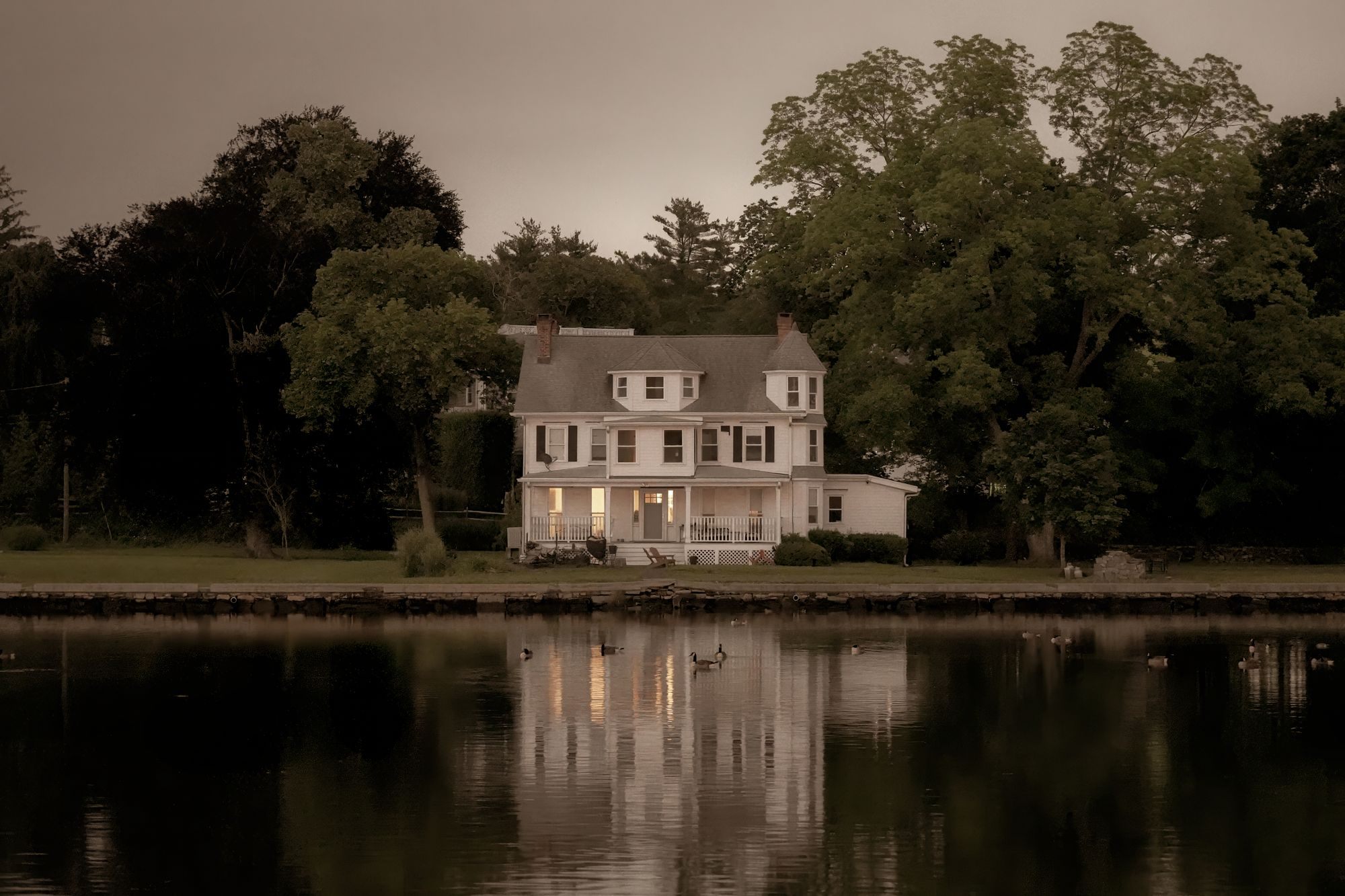 Waterfront home reflected in the water at twilight