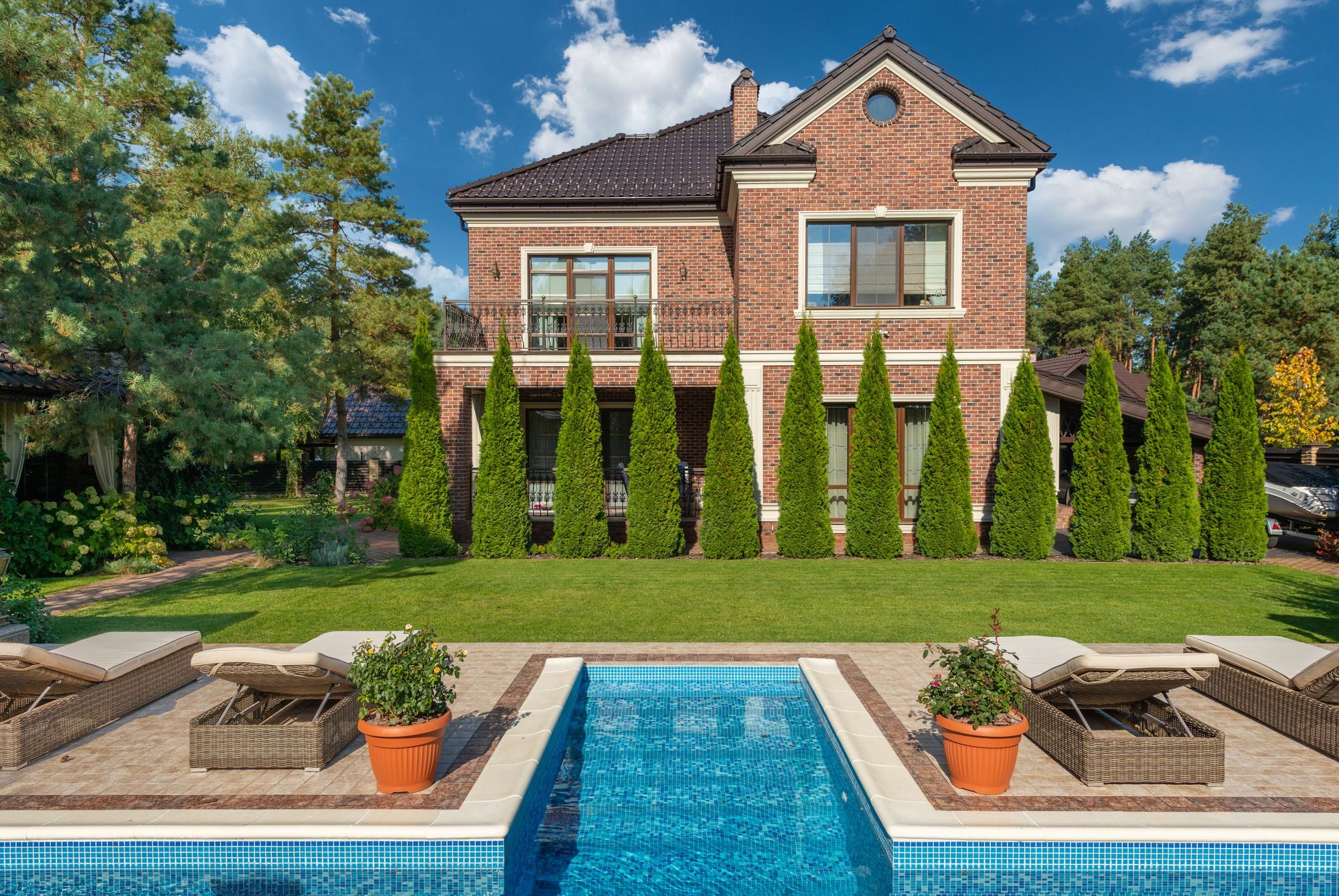 Brick villa with a pool and lawn