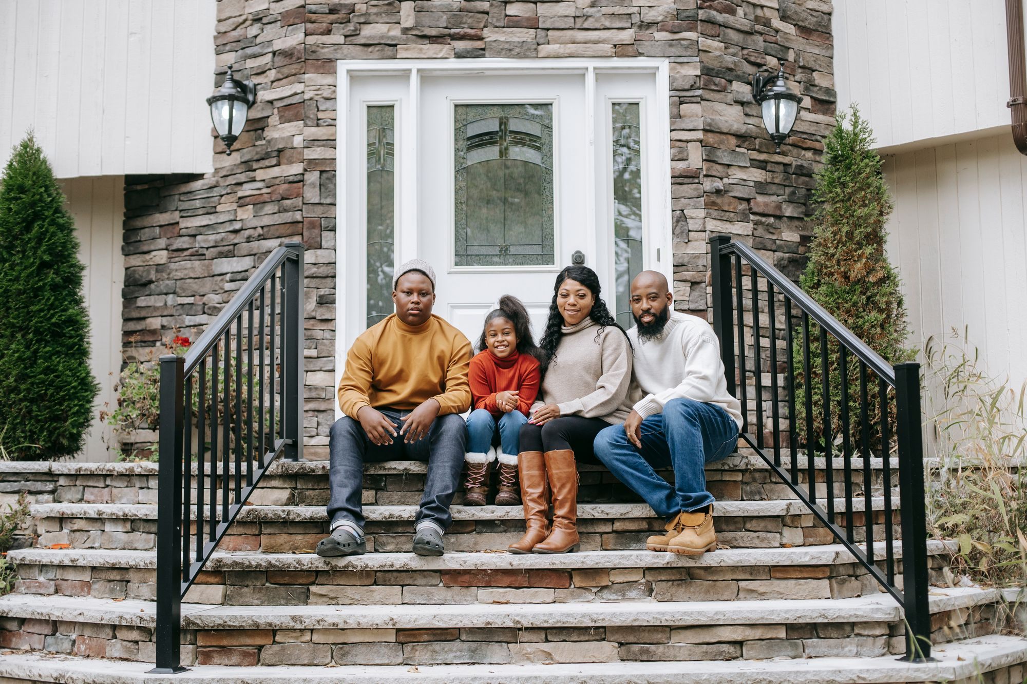 Parents with their two children on the steps of their home