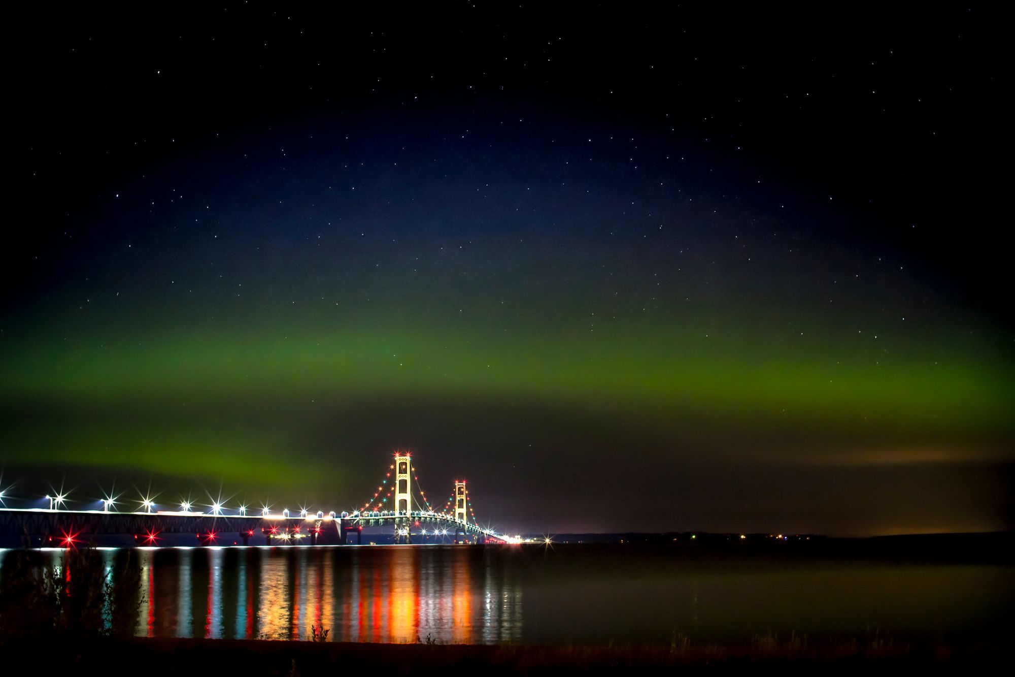 The Mackinac Bridge at night under the northern lights
