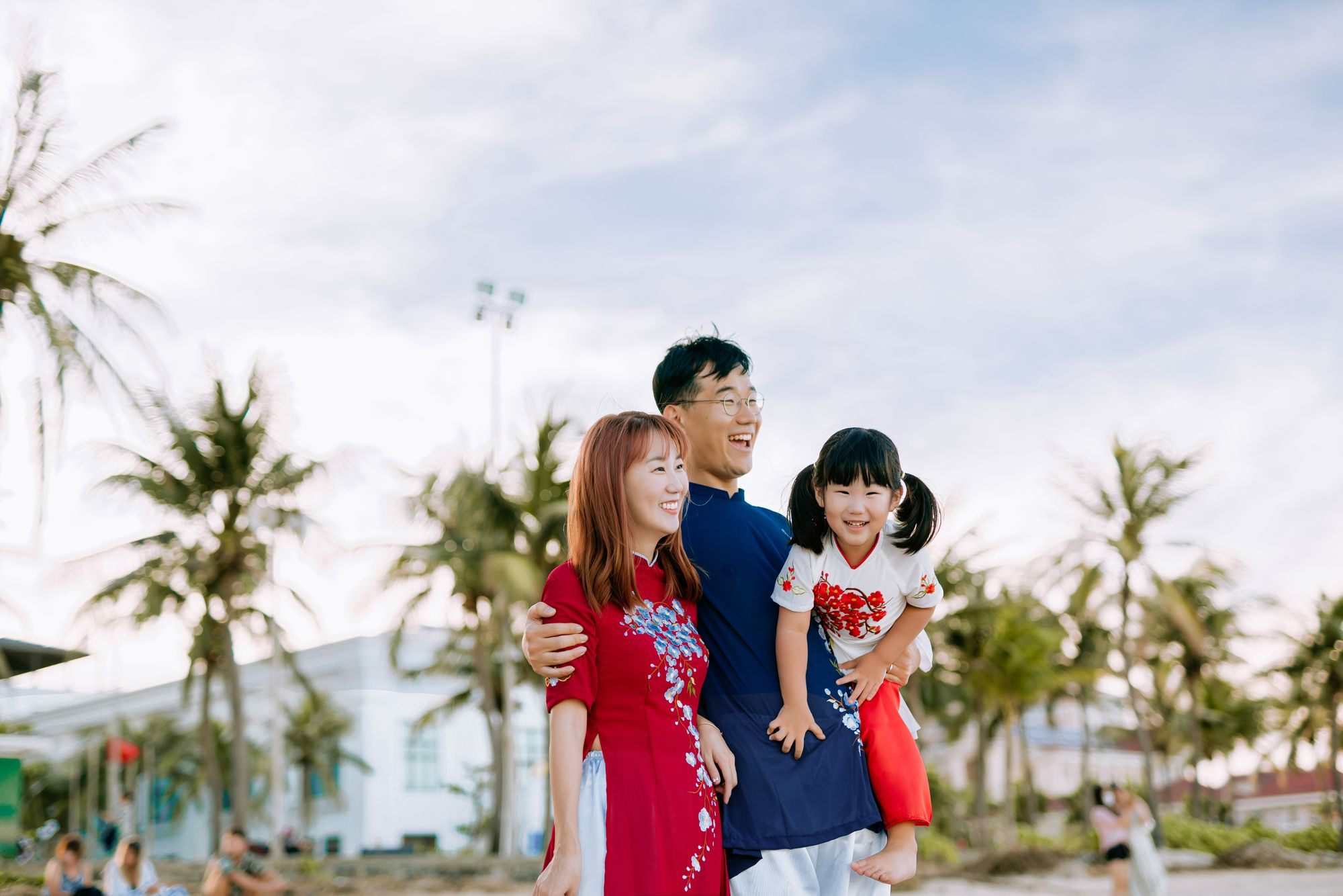 Young family smiling together in a sunny beachside town