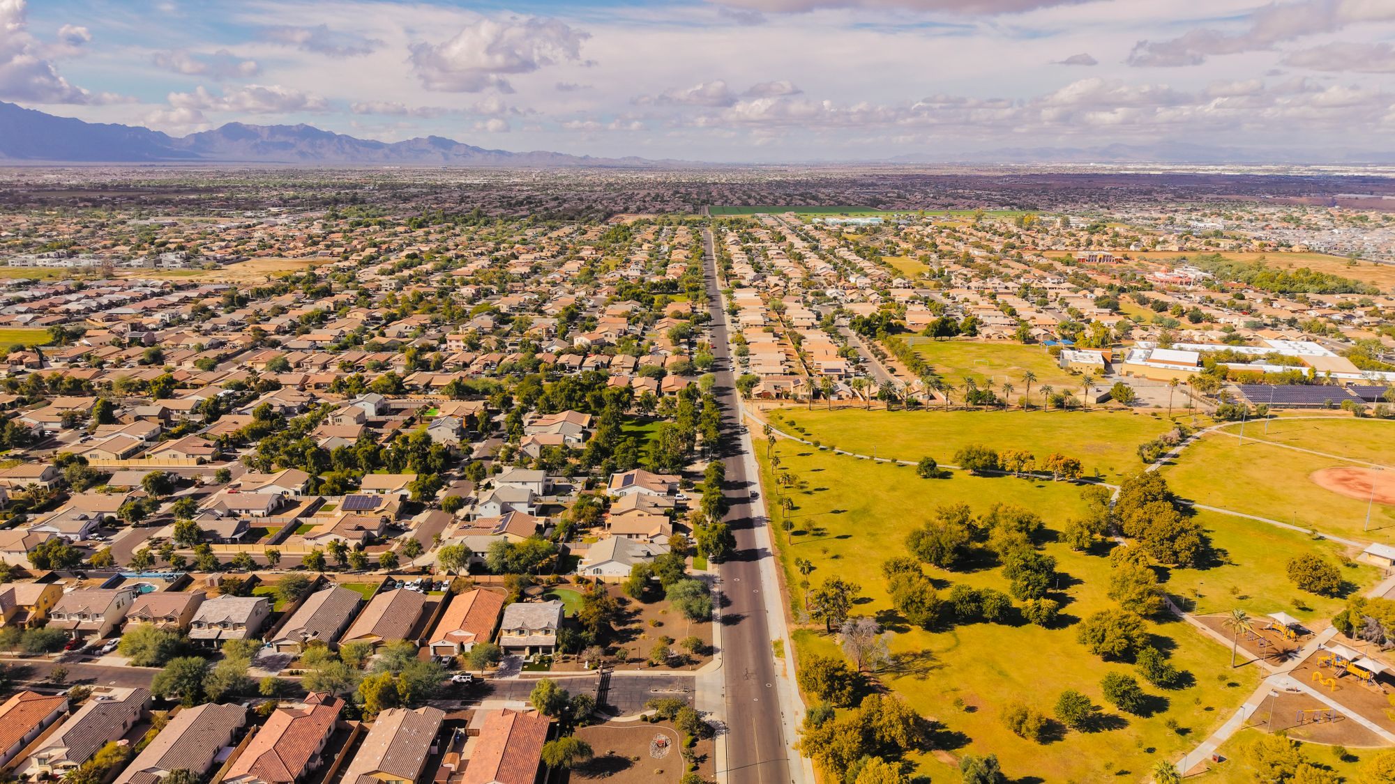 Aerial view of a Phoenix neighborhood with mountains beyond