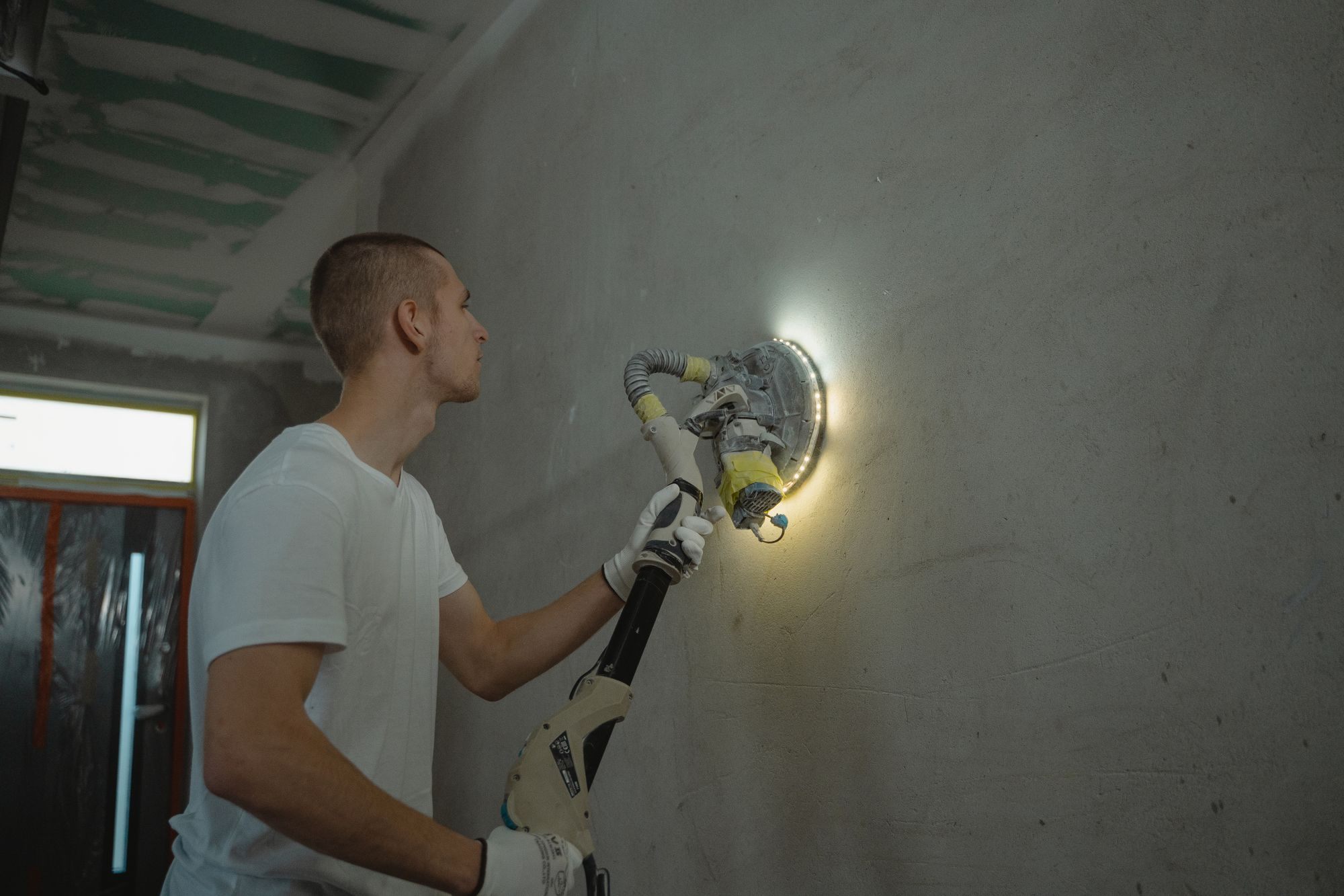 Tradesman finishing a drywall surface with a sanding tool