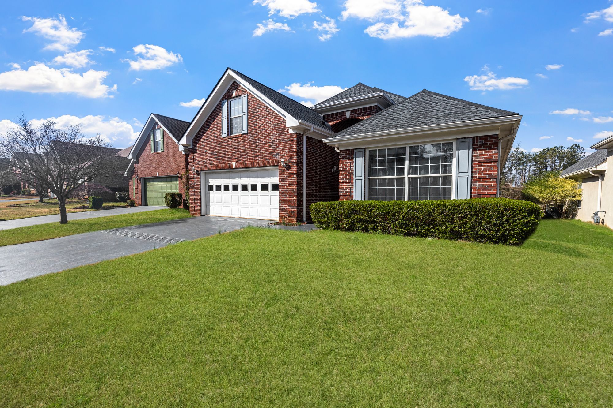 Brick home with a bright green lawn and attached garage