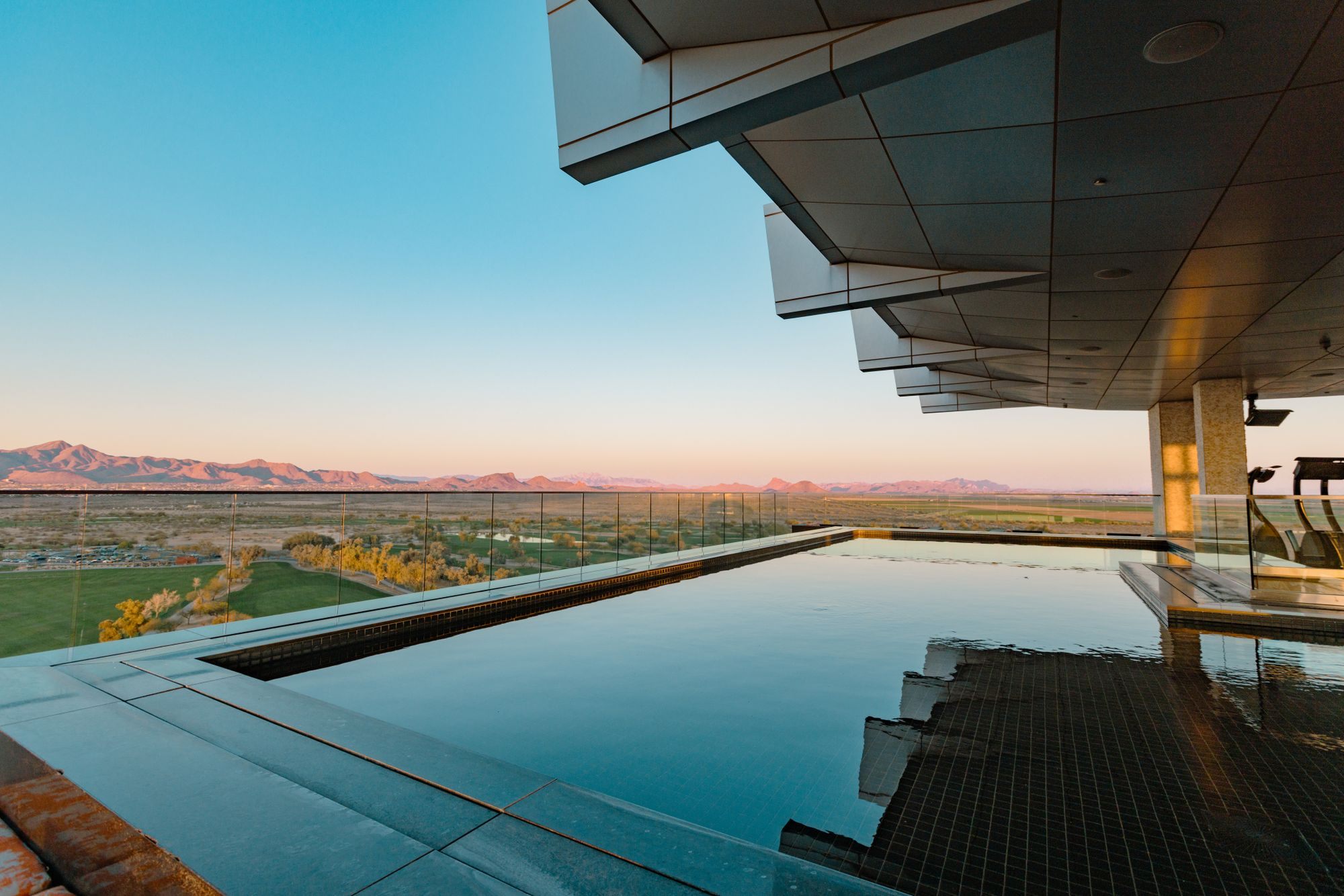 Infinity pool at a modern home overlooking the desert at dusk
