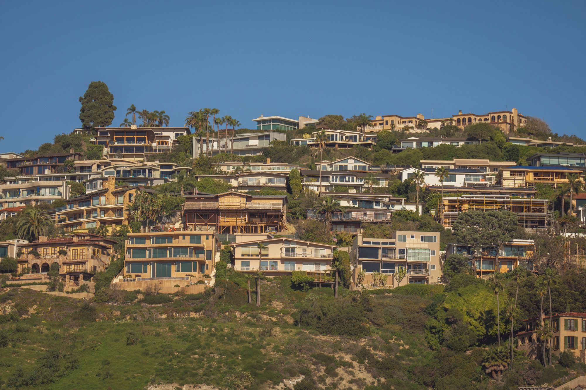 Hillside homes above the coast in golden evening light