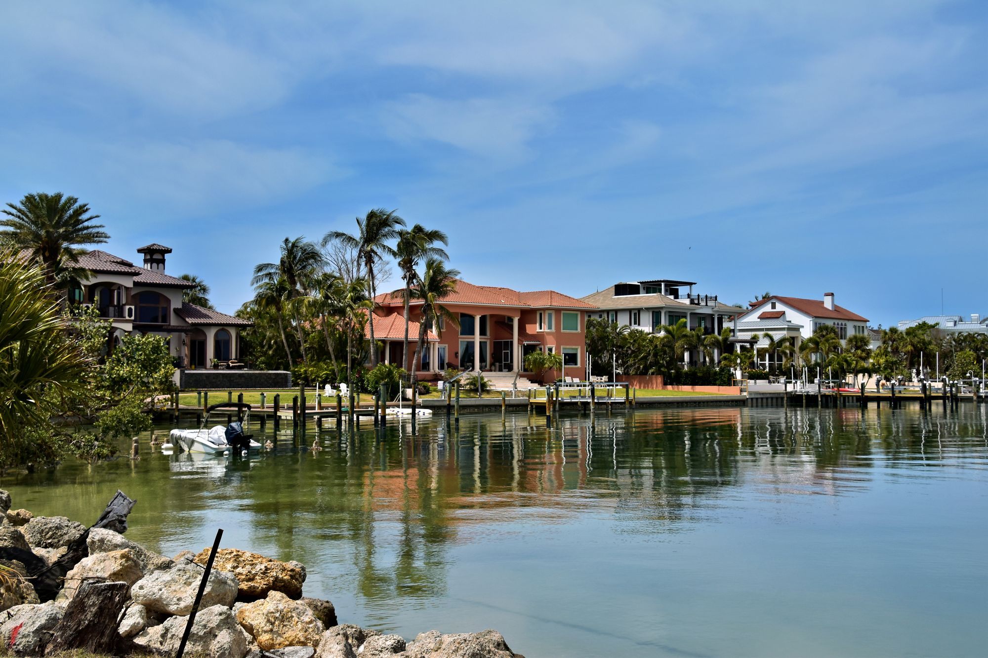 Waterfront homes with docks reflected in calm water