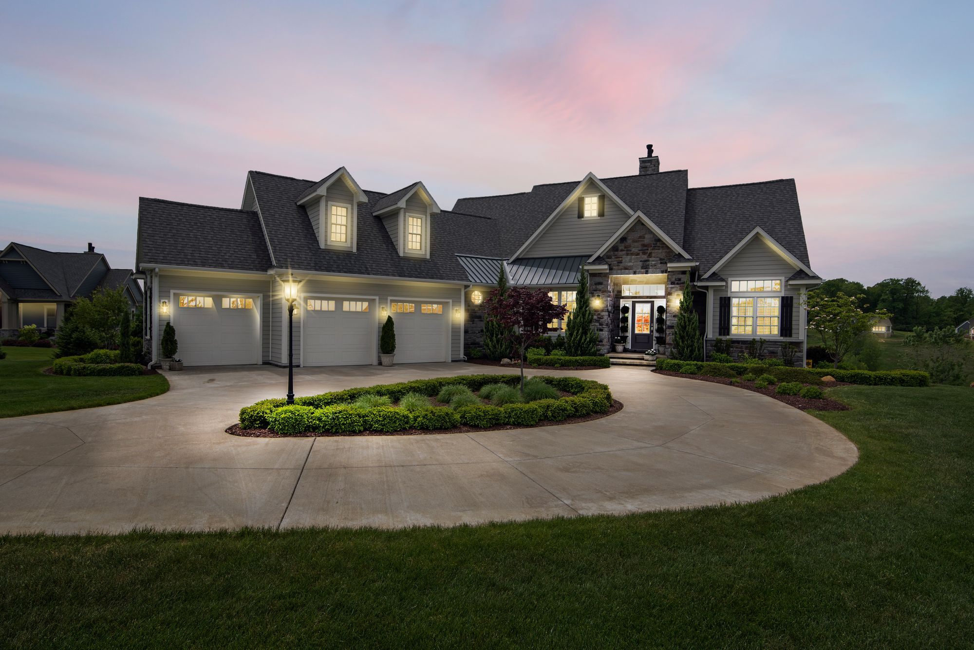 Large estate home with a circular driveway at dusk