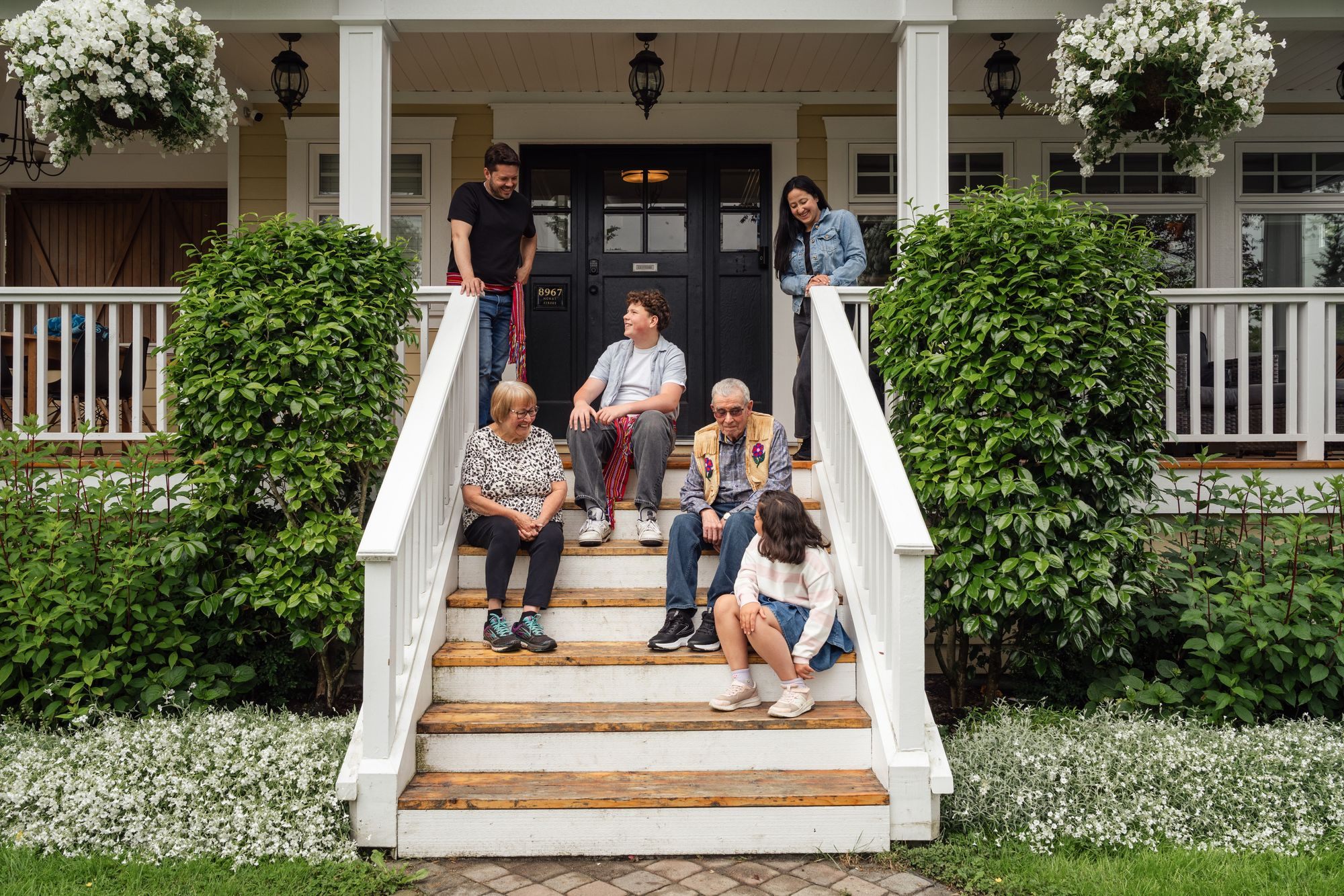 Family sitting together on the front steps of their home