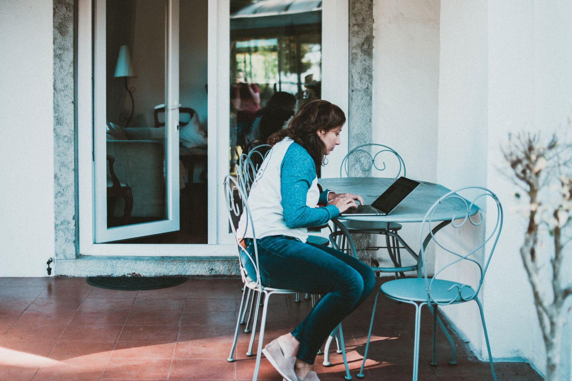 Homeowner working on a laptop at a patio table