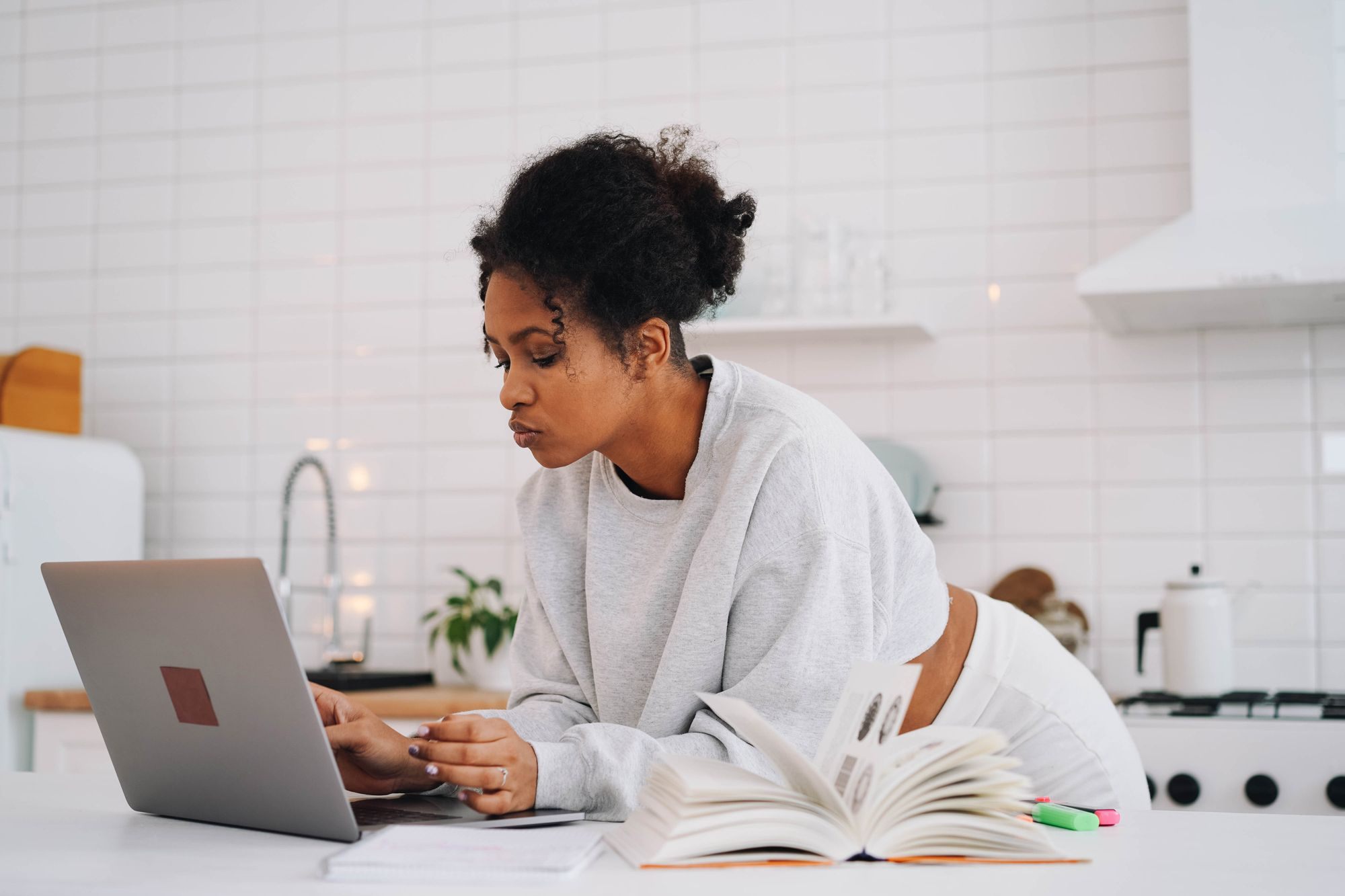 Woman working on a laptop at her kitchen table