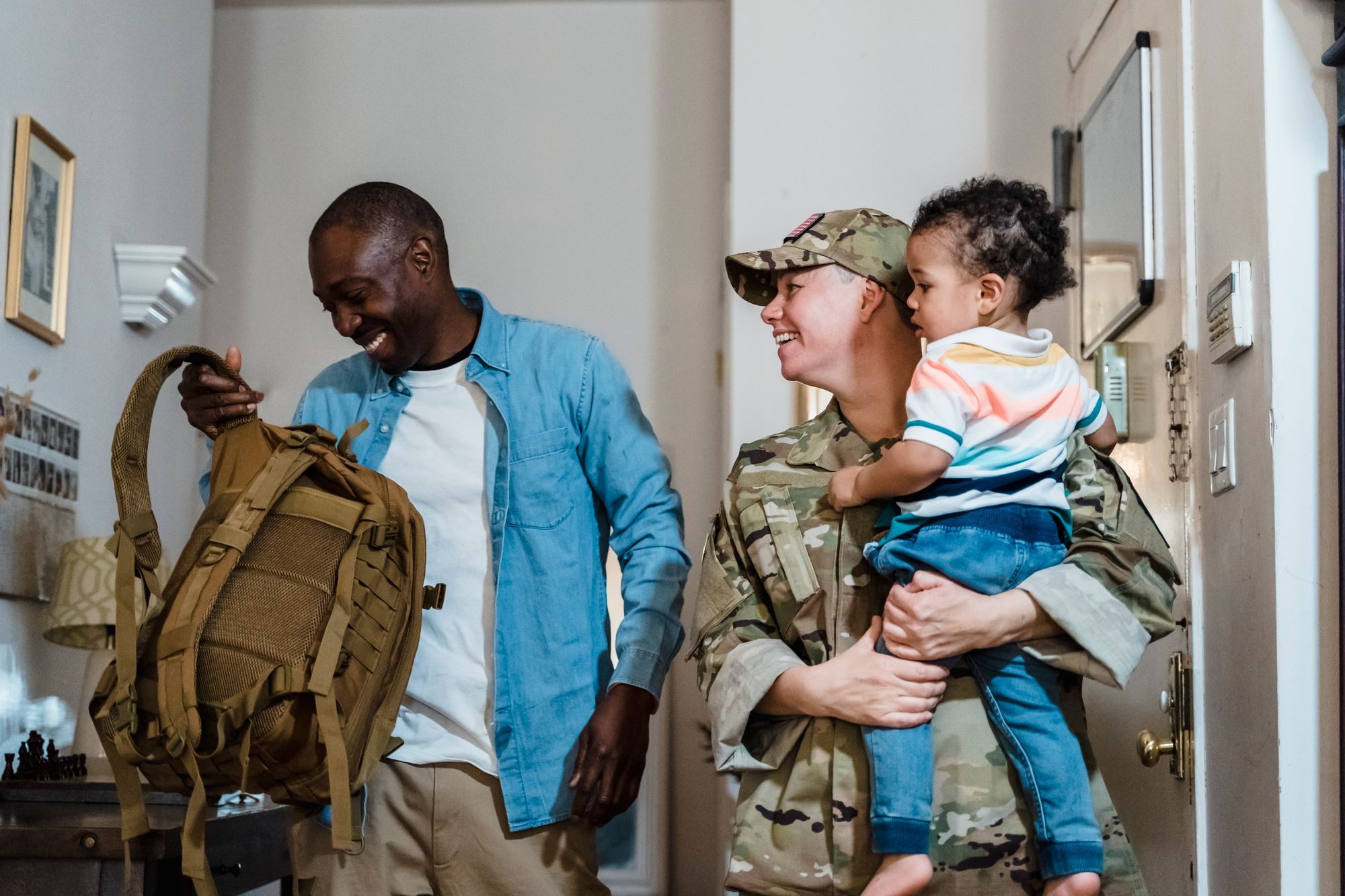 Soldier home on leave holding their child at the front door