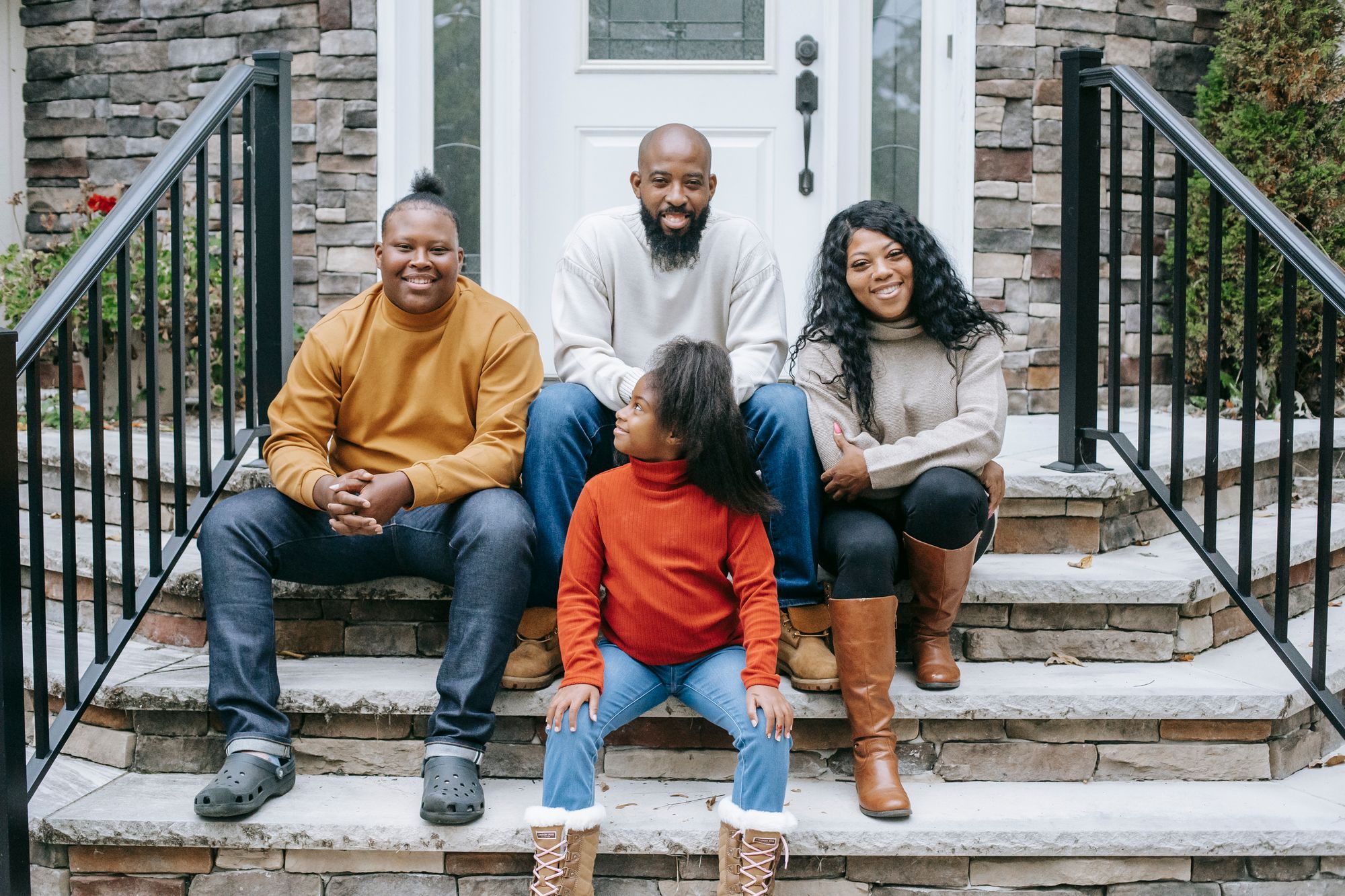 Family sitting on the front steps of their home
